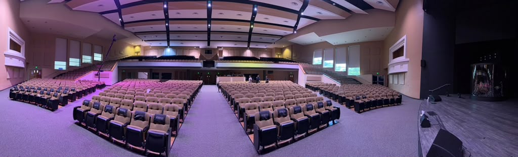 Panorâmica do auditório da Church In The Son, com os quatro blocos de poltronas, o balcão ao fundo e o palco à direita